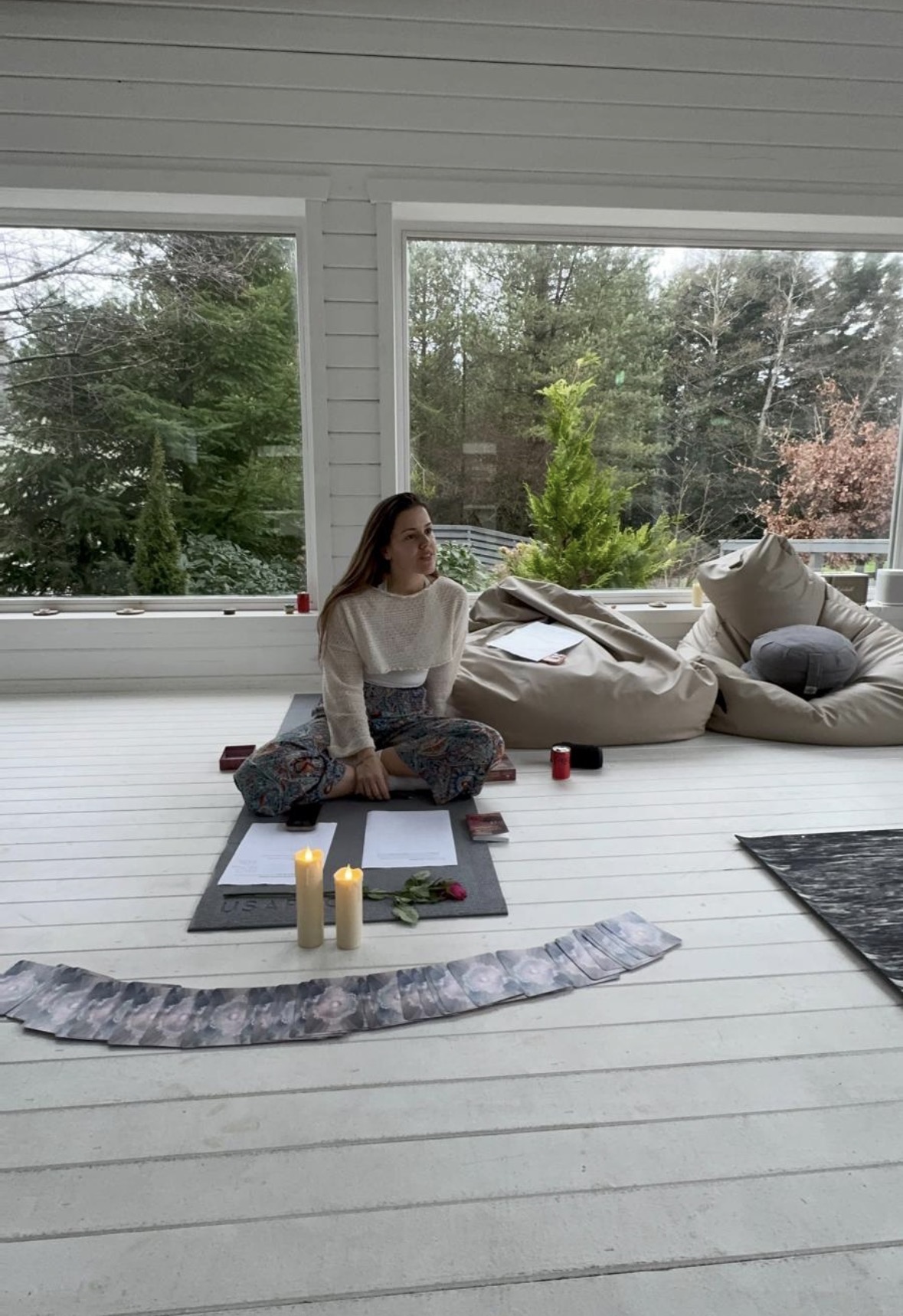 Eva meditating in the studio with candles and oracle cards